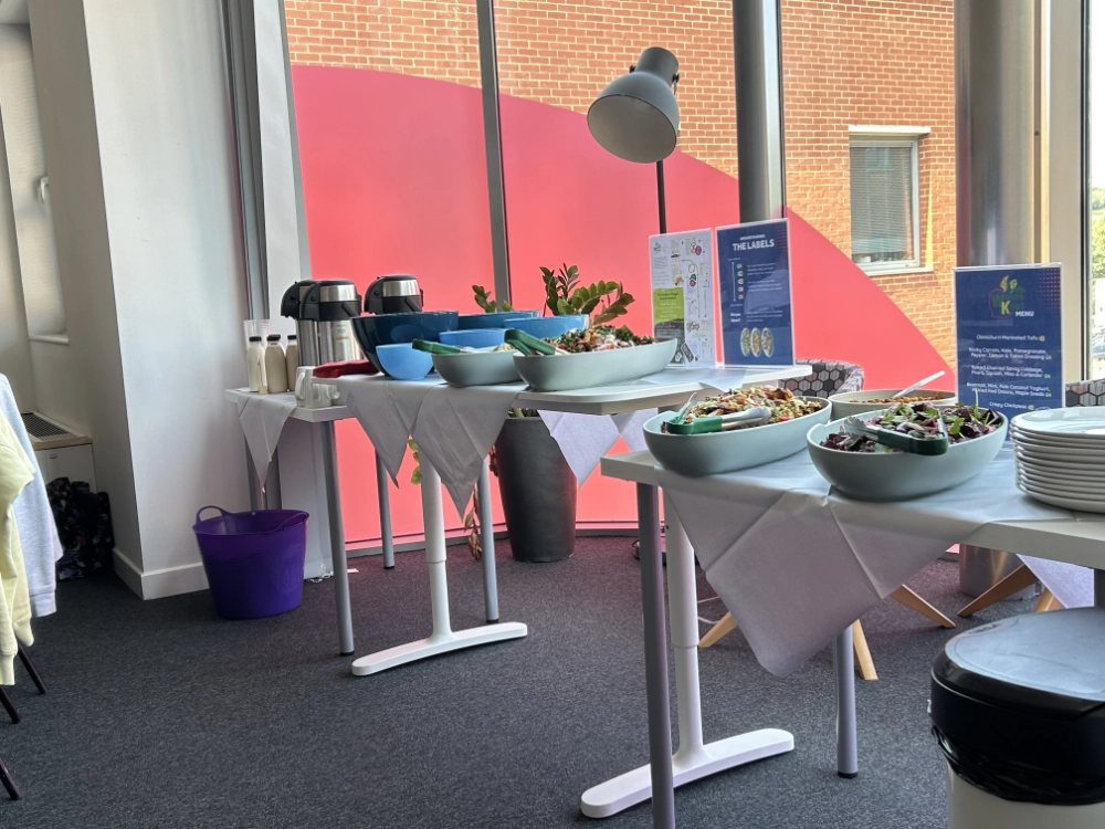A buffet is pictured with a range of bowls filed with salad, vegetable dishes and tofu. A beautifully presented menu information, coffee and tea.
