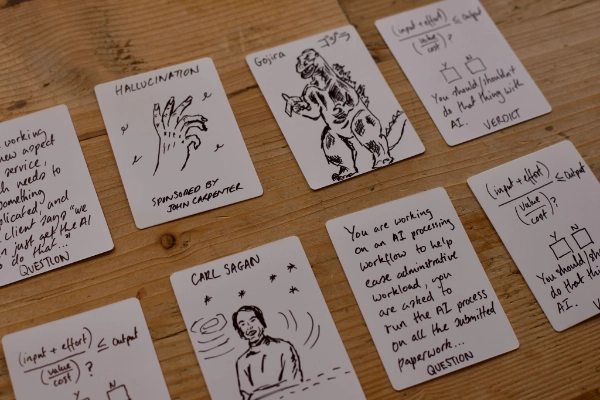 A selection of cards from the game including the Godzilla card, for manmade disaster, and the Carl Sagan Ethics card.