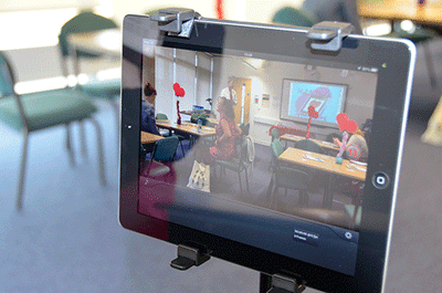 An iPad on a tripod video recording an activity in a room