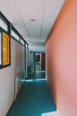 photo of a corridor in a modern building with a brigh orange wall on the right