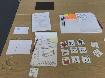 Interview kit on a table, with do not disturb sign, pens, post-its, and a card sorting exercise&rsquo;